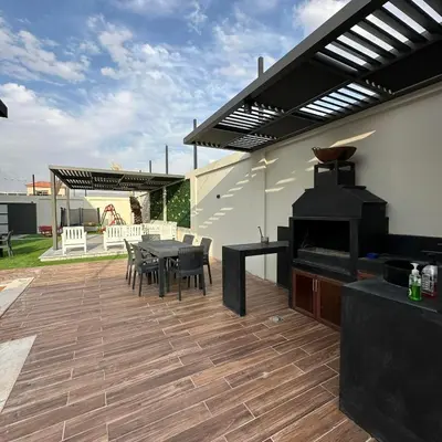a patio with a table and chairs and a grill at Z villas Chalet in Al Rama