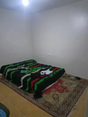 a bed sitting on top of a rug on a floor at ريمون هاوس in Kafr Khall