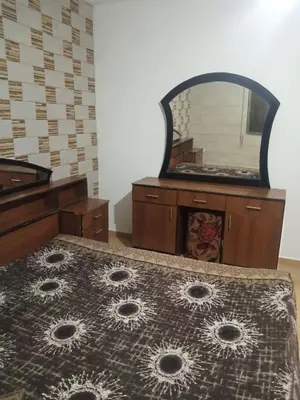 a bedroom with a dresser and a mirror at ريمون هاوس in Kafr Khall