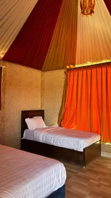 two beds in a room with a red ceiling at wadi rum luxury bubble soul in Wadi Rum