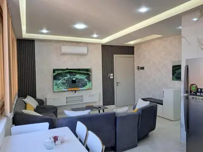 a living room with blue couches and a tv at منزل السعادة in Amman