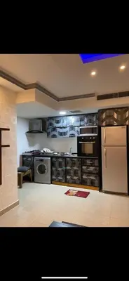 a kitchen with a stove and a refrigerator at Apartment in Al Jafr