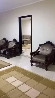 a room with a mirror and a chair and a rug at مليح هوستل