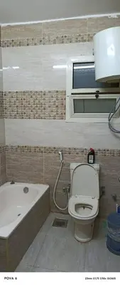 a bathroom with a toilet and a bath tub at مليح هوستل