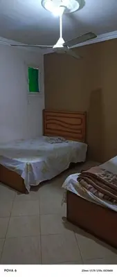 a bedroom with two beds and a ceiling fan at مليح هوستل