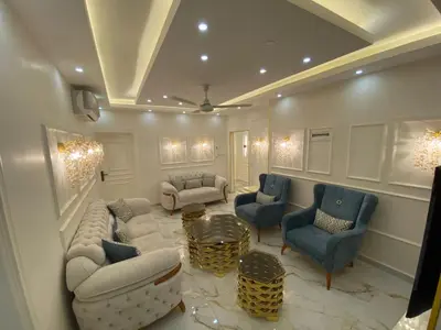a living room with couches and chairs and a table at Sanad Apartment شقة فندقية in Aqaba