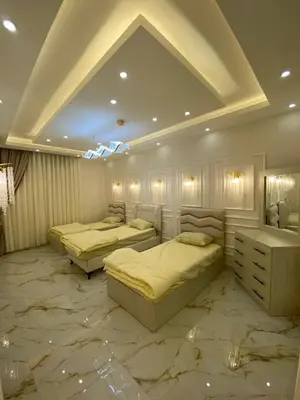 two beds in a room with marble floors at Sanad Apartment شقة فندقية in Aqaba