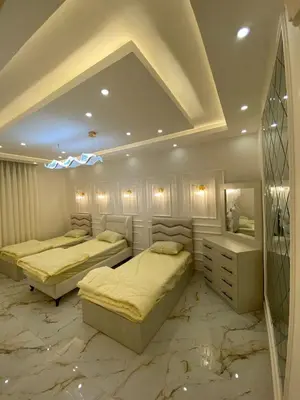 two beds in a room with marble floors at Sanad Apartment شقة فندقية in Aqaba
