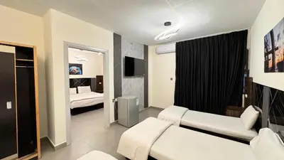 a bedroom with two beds and a tv in it at Eden Hotel in Aqaba