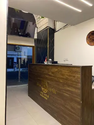 a reception desk in a building with a hotel sign at Eden Hotel in Aqaba