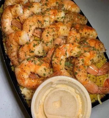 a tray of shrimp with a dipping sauce at وادي الشلاله هاوس in Al Mughayyir
