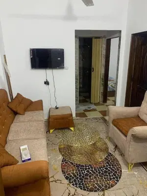 a living room with a couch and a tv at وادي الشلاله هاوس in Al Mughayyir