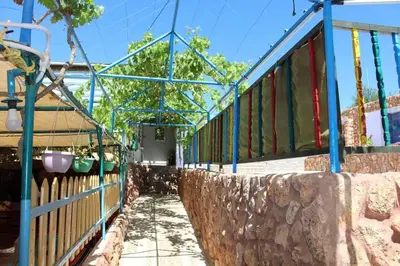 a building with colorful windows and a stone wall at استراحة ومنتجع قرية الزرب in Ajloun