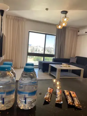 two water bottles sitting on a table in a living room at 2bedroom aprt at 7th circle f-r4 in Amman