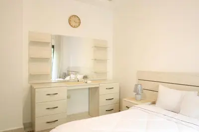a bedroom with a bed and a sink and a desk at Rams Der Ghbar 3BR cozy Apt in Amman