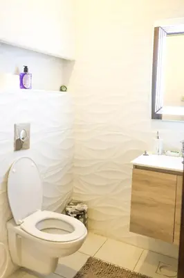 a bathroom with a toilet and a sink at Rams Der Ghbar 3BR cozy Apt in Amman