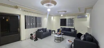 a living room with two blue couches and a table at الريان in Amman