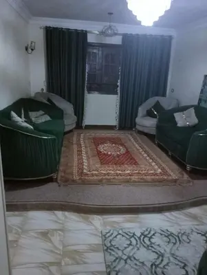 a living room with two green chairs and a couch at ام جوزه هاوس in Umm Jawzah