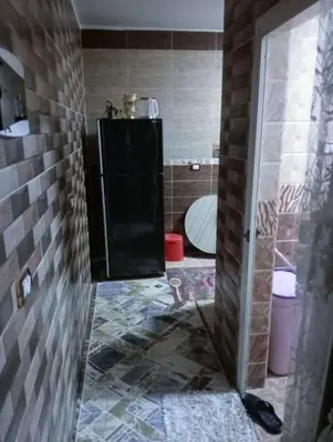 a bathroom with a toilet and a tiled floor at ام جوزه هاوس in Umm Jawzah
