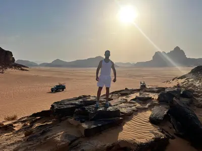 a man standing on rocks in the desert at SAHARA ECHO CAMP& Tour in Wadi Rum
