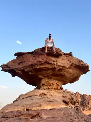 a man sitting on top of a rock at SAHARA ECHO CAMP& Tour in Wadi Rum