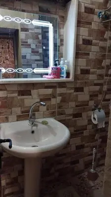 a bathroom with a sink and a mirror at بيت جدي in Dana