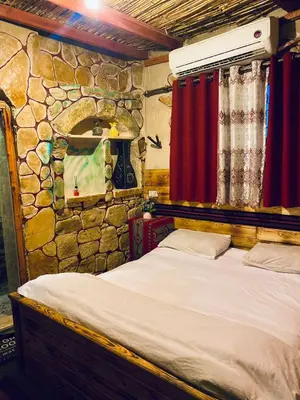 a bed in a room with a stone wall at بيت جدي in Dana