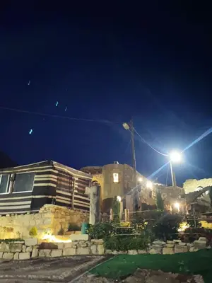 a house at night with a street light at بيت جدي in Dana