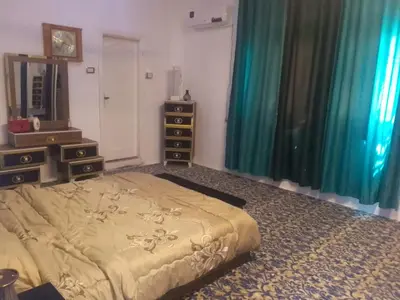 a bedroom with a bed and two dressers and a mirror at الخير لشقق المفروشه in Al Jafr