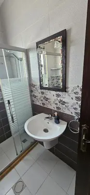 a bathroom with a sink and a shower and a mirror at شقة مفروشة في طبربور 3 غرف نوم in Amman
