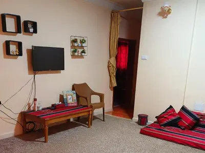 a living room with a table and a tv at Petra Triclinium Home in Wadi Musa