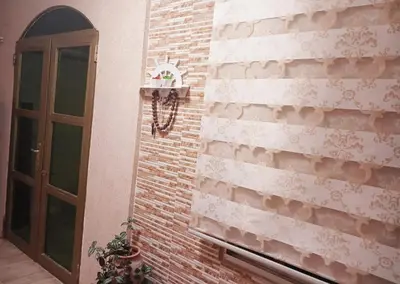 a brick wall with a door and a plant at Petra Triclinium Home in Wadi Musa