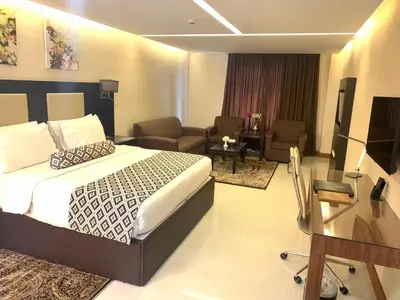 a hotel room with a bed and a living room at Olive Tree Amman in Amman