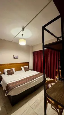 a bedroom with a bunk bed and a red curtain at Antika Amman Hotel in Amman