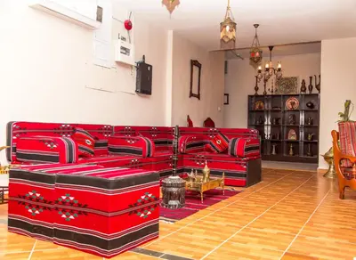 a living room with red couches in a room at Antika Amman Hotel in Amman