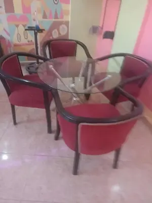 a glass table and chairs in a room at رميمين هاوس