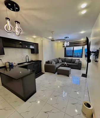 a large living room with a couch and a kitchen at Old Town Hotel in Aqaba