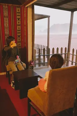 two women sitting in chairs looking out at the ocean at Rum marco luxury camp in Wadi Rum