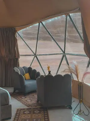 a living room with a couch and a large window at Rum marco luxury camp in Wadi Rum