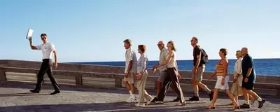 a group of people walking down a sidewalk with a frisbee at Tourist guide in Al Jafr