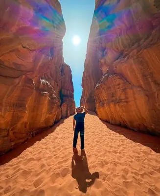 a person standing in the sand in the desert at Wadi Rum Sand Camp in Al Jafr
