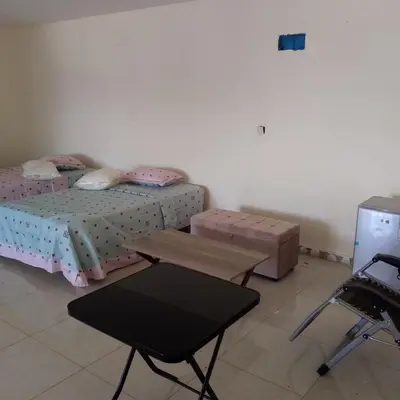 a bedroom with two beds and a table and a chair at New Room in Aqaba