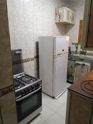 a kitchen with a white refrigerator and a stove at فلورس لوج