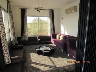 a living room with a purple couch and a window at اكواخ الملول عجلون 1 in ‘Ibbīn