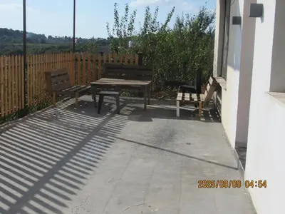 a picnic table and two benches on a patio at اكواخ الملول عجلون 1 in ‘Ibbīn