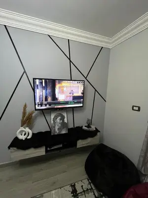 a living room with a flat screen tv on a wall at الضليل هاوس in Abū Ghārah