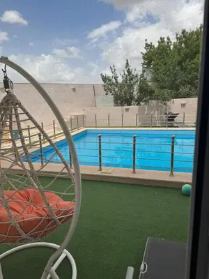 a view of a swimming pool from a playground at مزرعة وشالية هوى الوادي