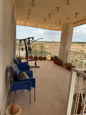 a patio with blue chairs and a view of the desert at مزرعة وشالية هوى الوادي