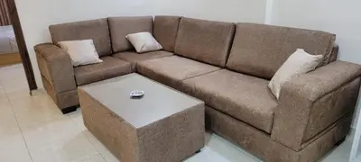 a brown couch with a table in a living room at النخبة للشقق الفندقية AlNukhba suites in Irbid