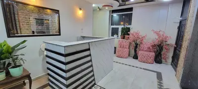 a lobby with a counter with pink chairs and plants at النخبة للشقق الفندقية AlNukhba suites in Irbid